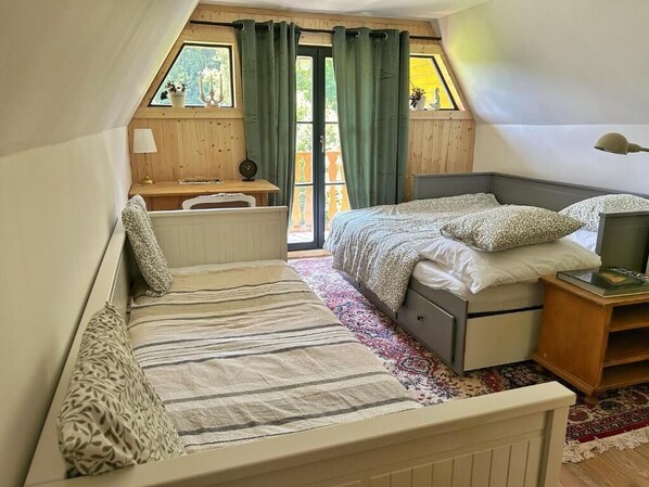 Un dormitorio con dos camas, un escritorio y una ventana con cortinas.