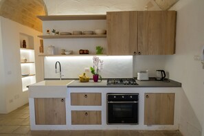 Een moderne keuken met houten kastjes, een ingebouwde gootsteen, een fornuis en een vaatwasser.