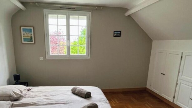 Una camera da letto con un letto, una finestra, un comodino e un armadio.