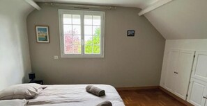 A bedroom with a bed, a window, a nightstand, and a wardrobe. - The Gîte des Pélus, perfect for a getaway in the countryside, less than 10 minutes from Tours. (Rochecorbon)