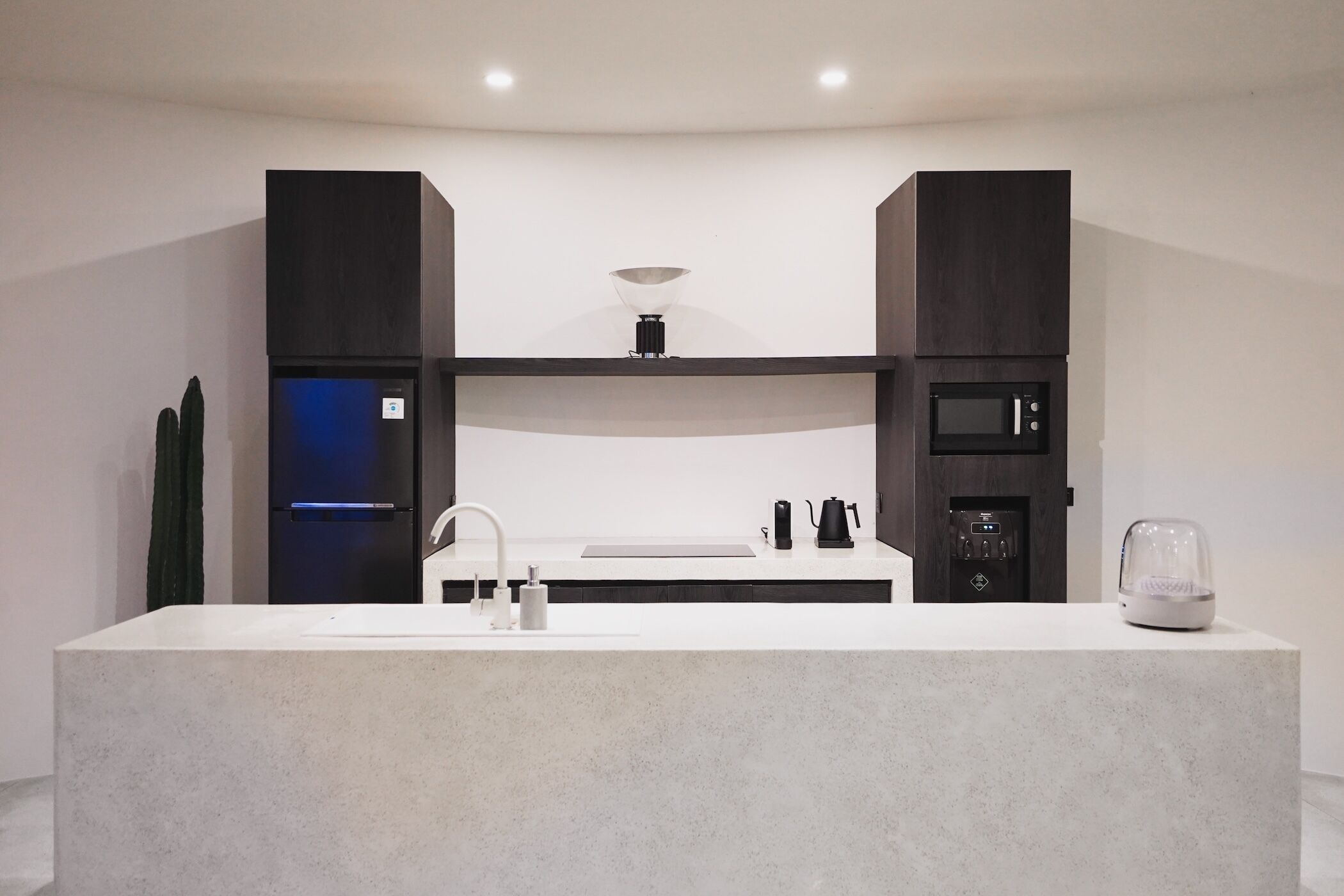 Una cocina moderna con una isla central, electrodomésticos integrados y un diseño minimalista.