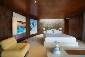 A modern hotel room with a large bed, a seating area, and artwork on the walls. - Nya Uluwatu (Pecatu)