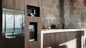 A modern kitchen with a built-in oven, a sink, and a coffee machine. - Nya Uluwatu (Pecatu)