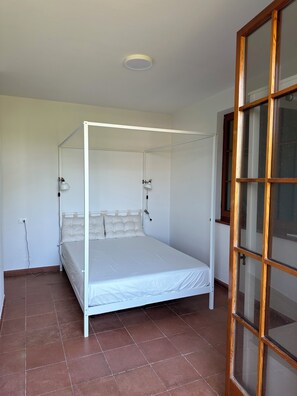 A room with a four-poster bed, a window with wooden frames, and a tiled floor. - Sant'Elme 87 (Forte dei Marmi)