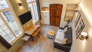 Een modern interieur met een eethoek, een bank en een aan de muur bevestigde televisie.