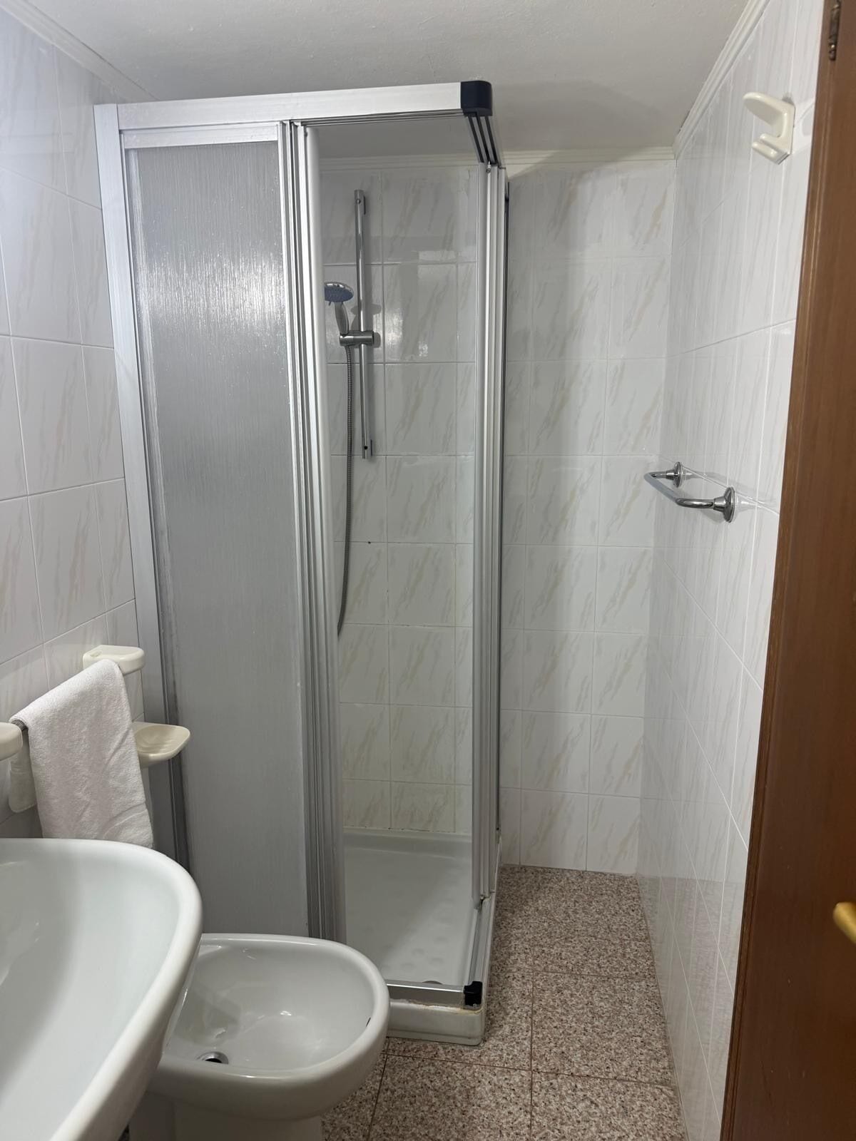 Ein Badezimmer mit Duschkabine, Waschbecken und Toilette.