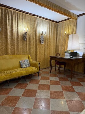 A room with a yellow sofa, a wooden desk, and a patterned curtain. - ALLOGGI ALLA SCALA (Venice)