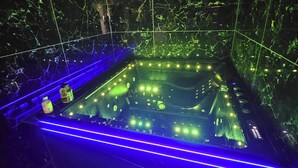 Spa-område med jacuzzi, blå LED-belysning og marmorvægge.