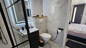 Et moderne badeværelse med toilet, vask og spejl.