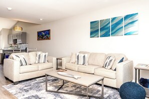 Een moderne woonkamer met een zithoek, een salontafel en een vloerkleed.