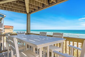 Un patio frente al mar con una mesa y sillas, con vista al océano.