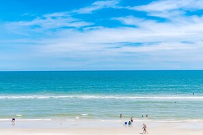 Une plage avec un ciel dégagé et une mer calme.