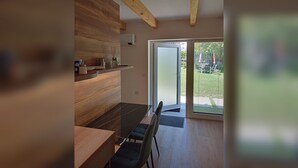 Et moderne køkken med træskabe og et spiseområde med et glasbord.