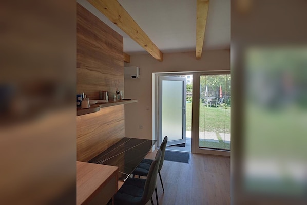 A modern kitchen with wooden cabinetry and a dining area with a glass table.