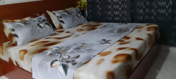 A bed with a floral bedspread and matching pillows.