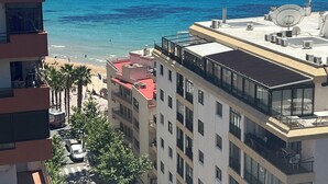 A high-rise building with multiple balconies overlooking a beach and the sea. - Sea View Retreat - Beachfront Two-Bedroom Penthouse (Calpe)