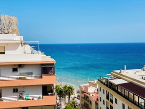 A coastal building with balconies overlooking a beach and the sea. - Sea View Retreat - Beachfront Two-Bedroom Penthouse (Calpe)
