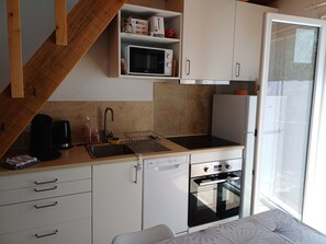 Eine kleine Küche mit Mikrowelle, Toaster und Kühlschrank.