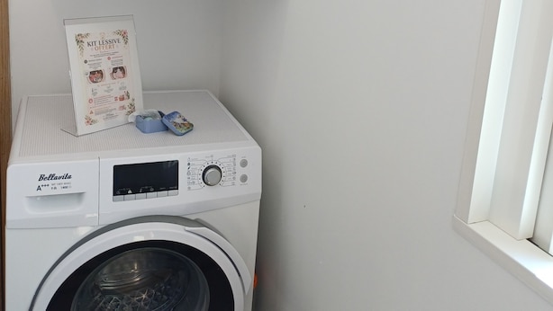 A compact laundry area with a washing machine, a shelf above it, and a window to the right. - Victor's House at the Foot of Sainte Victoire (Vauvenargues)