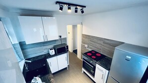 Una cocina moderna con horno empotrado, refrigerador y tostadora sobre la encimera.