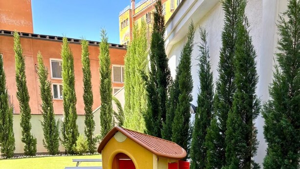 En lekplats för barn med ett litet hus och en rutschkana.