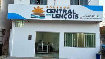 Um edifício com uma placa indicando 'Pousada Central Lencóis' e um número de contato.