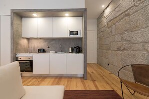 Eine kompakte Küche mit modernen Geräten, einer Mikrowelle und einer Kaffeemaschine.