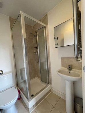 Ein Badezimmer mit Duschkabine, Waschbecken und Toilette.