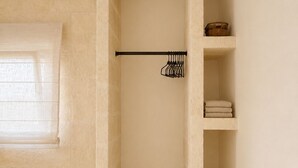 Une salle de bain minimaliste avec un porte-serviettes, des étagères et une petite boîte en bois.