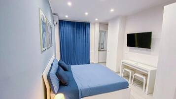 Una camera da letto moderna con un letto, una lampada da comodino e una scrivania con una sedia.