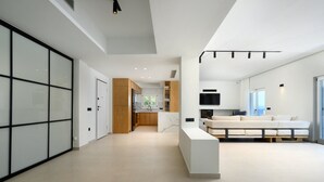 Un interior moderno con cocina, sala de estar y un amplio ventanal corredera.