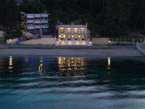Ein Wassergrundstück mit einem Gebäude, das mehrere Balkone und einen Teich besitzt, in dem sich die Umgebung spiegelt.