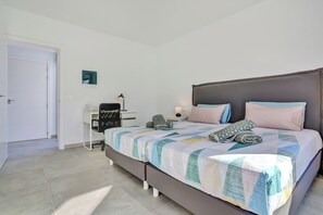 Une chambre à coucher avec un lit, un bureau, une chaise et une table de chevet.