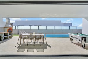 A modern outdoor patio with a pool table, seating area, and a barbecue grill. - Maripos as Lajares 1, a peaceful location just a 5-minute walk from the town center. (La Oliva)