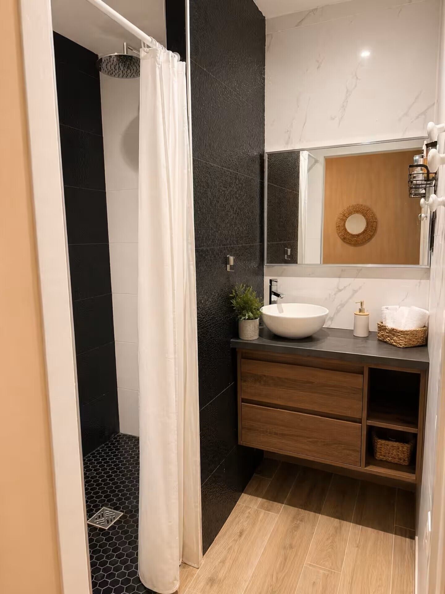 A modern bathroom with a shower, a sink, and a mirror.