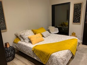 A bed with patterned bedding and a yellow throw blanket. - Casa Supranu - Large family villa in the heart of Alta Rocca (Altagène)