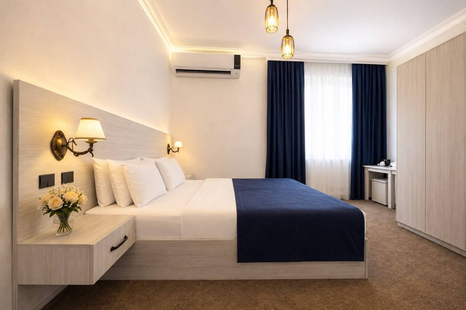A hotel room with a bed, bedside lamps, a desk, and a window with curtains.