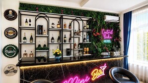 A bar area with a neon sign reading 'Mini Bar' and a variety of liquor bottles on shelves. - Central Way Baku (Baku)