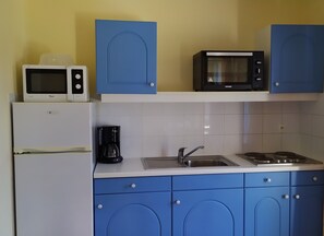 A kitchen with a refrigerator, microwave, coffee maker, sink, and stove. - The charm of a Provençal cottage, for a family vacation near Uzès (Gaujac)