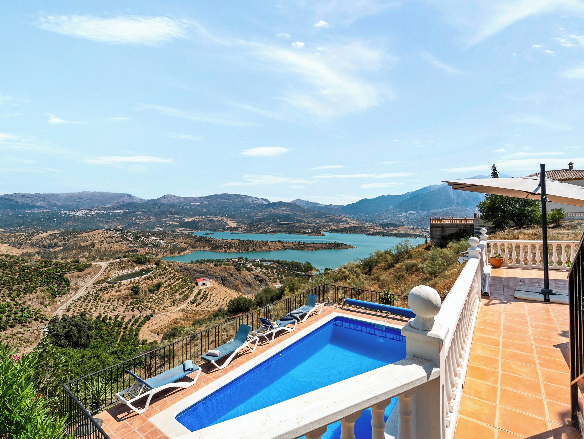 A pool with a view of a lake and mountains.