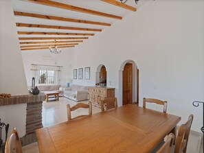 A spacious living area with a dining table, wooden beams, and a view to the outside. - Casa Juan for 8 people, with a private pool, a patio with a grill, and a magnificent lake view (Viñuela)