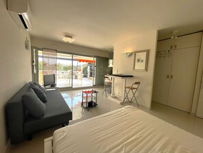 A modern bedroom with a large bed, a sofa, a desk with chairs, and a wardrobe. - 1-BR Villa with Terrace and Air Conditioning - Cap d'Agde (Cap d'Agde)