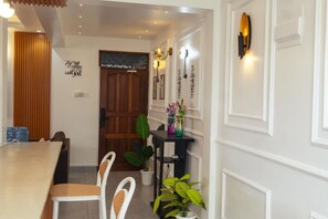 A dining area with a wooden table, white chairs, and a potted plant. - Luxury 2-Bedroom Apartment in Nyali with Pool & Beach Access in Mombasa (Mombasa)