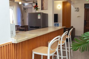 Eine Küche mit integriertem Kühlschrank, Holzvertäfelung und weißen Barhocker.