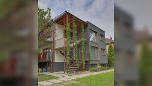 A modern two-story house with a visible staircase and a small garden area. - Modern Villa in a Quiet Residential Area (Hradec Králové)