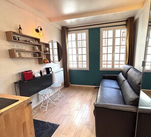 Ein gemütlicher Wohnbereich mit Sofa, Esstisch und Küchenzeile.