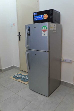 Uma geladeira compacta com visor digital, compartimento para congelador e adesivo indicando eficiência energética.