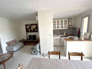 A modern living room with a sofa, a coffee table, and a TV. - Comfortable apartment with air conditioning - 6 guests (Argelès-sur-Mer)