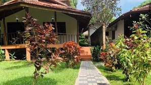 A pathway leading to a building with a porch and a garden with various plants. - Goyambokka Beach Retreat (Tangalle)
