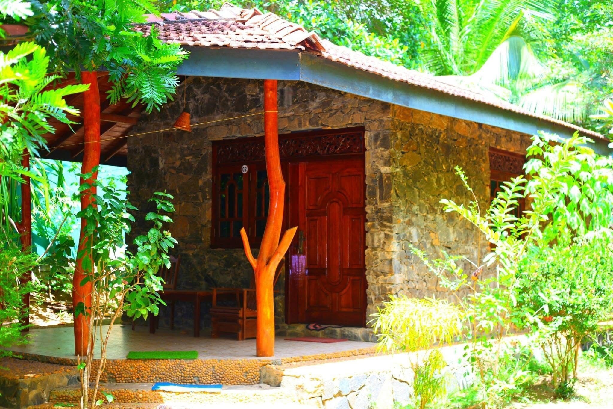 Un edificio de piedra con techo de tejas, una puerta de madera y un pequeño porche.